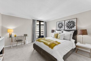 Quarto moderno com uma cama grande, uma escrivaninha e uma cadeira.