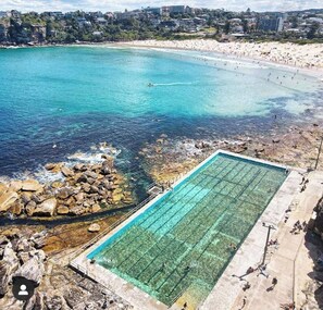 A coastal swimming pool with clear water, surrounded by rocky terrain and a beach. - Minutes walk to Beach, Village and Restaurants. Family size home (Freshwater)