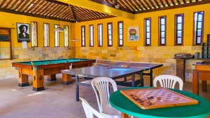 A billiards room with a pool table, a ping pong table, and a chess table. - Espaço Daltro - 5,000m² of trees with full infrastructure, 2km from Guarajuba (Camaçari)