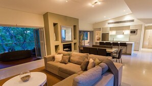 A modern living room with a sofa, a coffee table, and a dining area with chairs. - Flutes Escape - Located on the exclusive Brookland Valley Vineyard property (Wilyabrup)