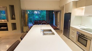 A modern kitchen with a central island, stainless steel appliances, and a view of the outdoors. - Flutes Escape - Located on the exclusive Brookland Valley Vineyard property (Wilyabrup)
