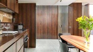 A modern kitchen with wooden cabinets and a dining area with a wooden table and chairs.