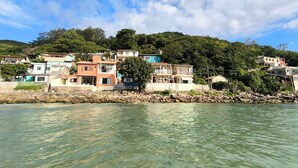 Un village côtier avec des immeubles à étages, une côte rocheuse et un ciel bleu dégagé.