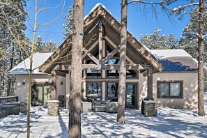 A lodge with a large entrance, stone pillars, and a covered patio area. - Custom Angel Fire Home: Views, Hot Tub & Fire Pit! (Angel Fire)