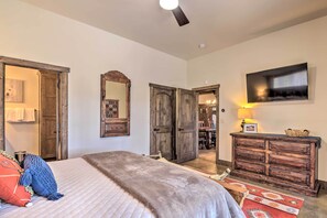 A bedroom with a bed, wooden wardrobe, and a television mounted on the wall. - Custom Angel Fire Home: Views, Hot Tub & Fire Pit! (Angel Fire)