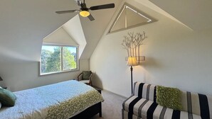 A bedroom with a bed, a ceiling fan, a window, a lamp, and a sofa. - Peaceful 40-acre Gembrook Farmstay & Sanctuary - Help feed rescue animals! (Gembrook)
