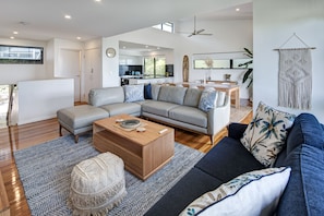 A modern living room with a grey sofa, a wooden coffee table, and a blue rug. - Pinnacle 5, Pinnacle 5 on Hamilton Island (Hamilton Island)