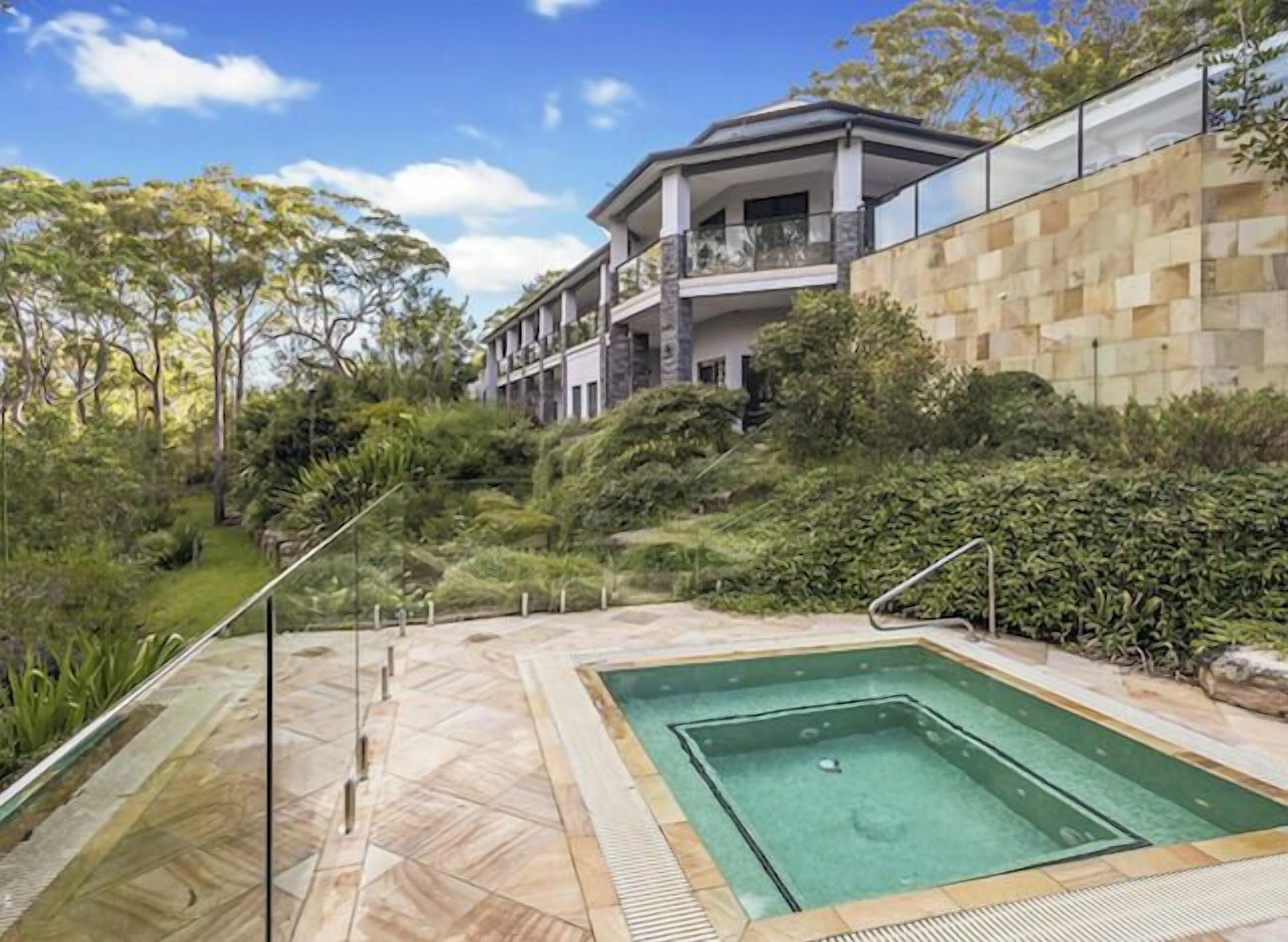 Un edificio moderno con piscina y vegetación circundante.