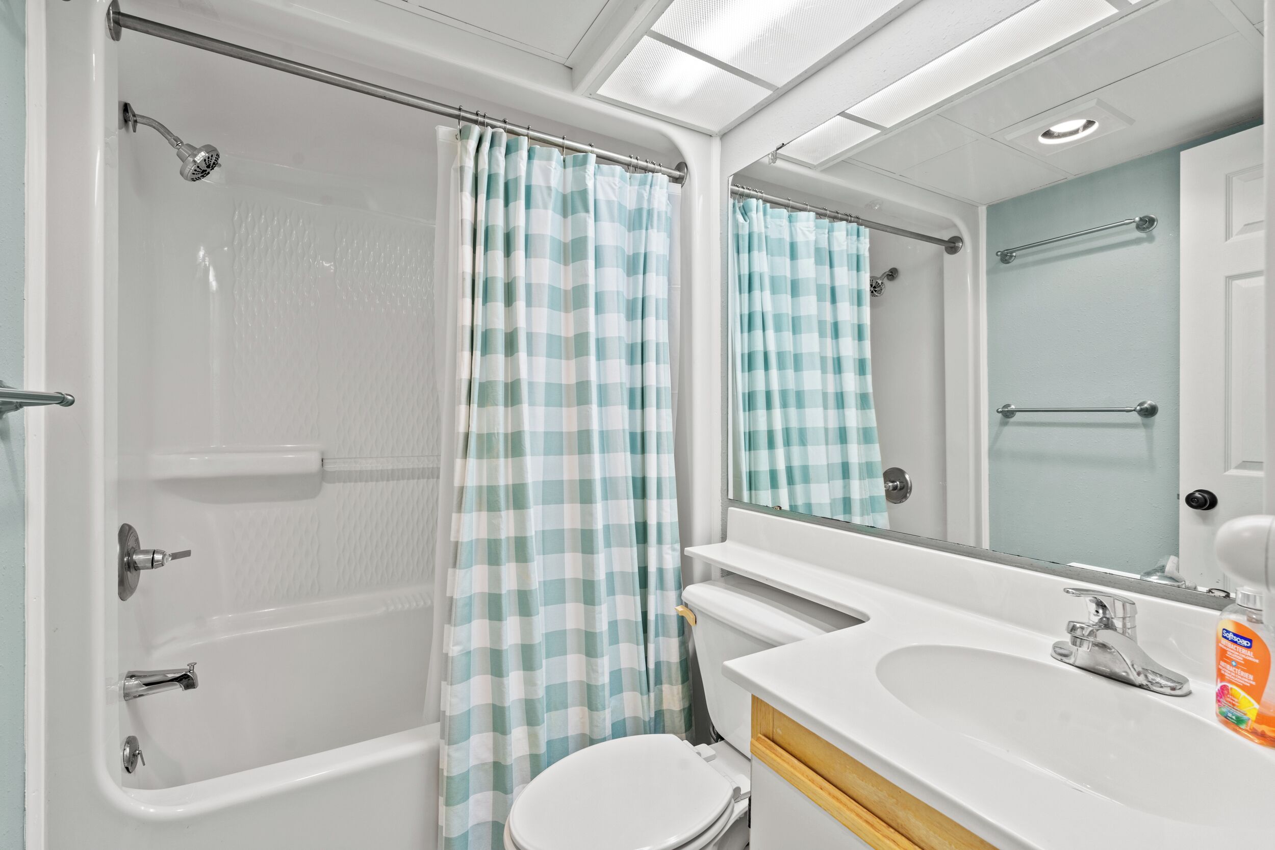 A bathroom with a bathtub, a toilet, a sink, and a mirror.