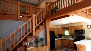 A spacious kitchen with wooden cabinets, a black refrigerator, and a microwave. - Masthope modern log-cabin sided retreat! (Lackawaxen)