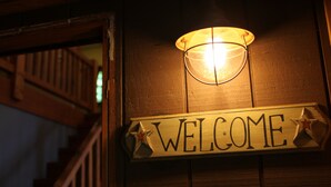 A wooden welcome sign with a light fixture above it. - Masthope modern log-cabin sided retreat! (Lackawaxen)