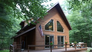 A log cabin with a deck, large windows, and an American flag. - Masthope modern log-cabin sided retreat! (Lackawaxen)