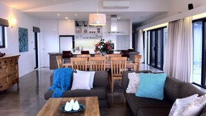 A modern living room with a sofa, coffee table, and dining area.