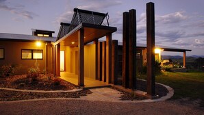 A modern house with a covered porch, large windows, and a well-maintained garden.