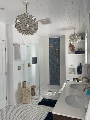 Een bad/douchecombinatie, een bubbelbad, een haardroger, handdoeken