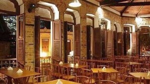 Ein Restaurant mit Holztischen und -stühlen, Backsteinwänden und Rundbogenöffnungen.
