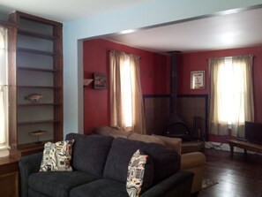 A living room with a fireplace, a sofa, and a bookshelf.