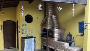 Uma cozinha com forno de tijolos, pia e porta.