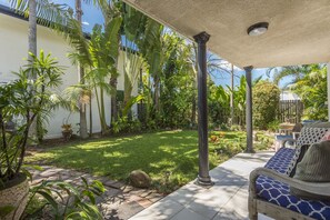 A covered patio with a garden, a bench, and a pergola. - BESAKIH @ BYRON BAY Seconds to town & beach , large Private garden, pet friendly (Byron Bay)