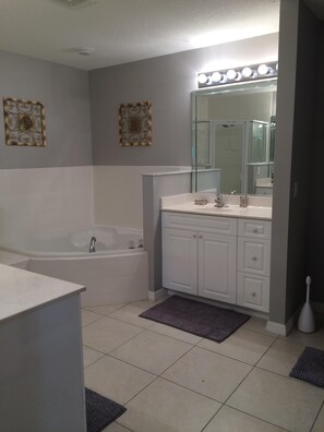 Ein modernes Badezimmer mit einer Badewanne, einem Waschtisch mit Spiegel und einer Toilette.