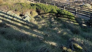 A beach with a wooden walkway and rocky terrain.
