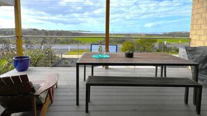 A covered outdoor seating area with a view of the landscape.