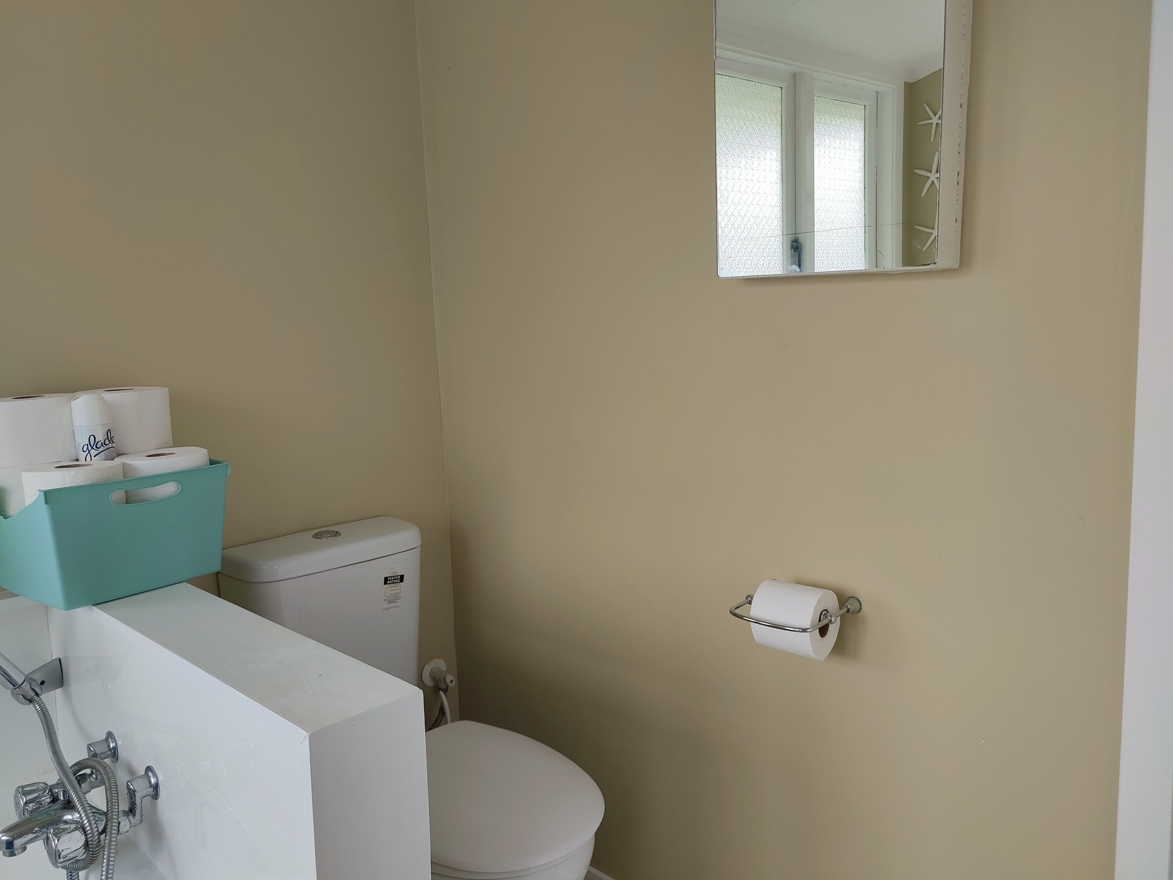 Un baño pequeño con inodoro, lavamanos y espejo.