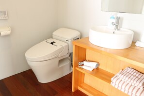 A bathroom with a toilet, a sink, and a towel rack. - OceanVilla Yuninohama (Miyakojima)