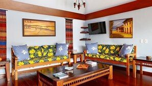 Uma sala de estar com dois sofás, uma mesa de centro e uma televisão.