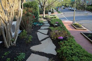 A garden pathway with stepping stones, surrounded by various plants and shrubs. - Capitol Hill Delight With Patio (Washington)