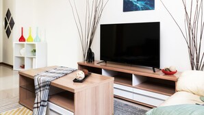 A modern living room with a flat-screen TV, wooden furniture, decorative vases, and a painting on the wall. - Modern Building in City Center 3/2bath across Taipei Main Station (Taipei City)