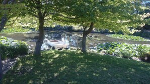A boat docked near a pond surrounded by trees and greenery. - ALTONA GARDEN RETREAT (spreyton)