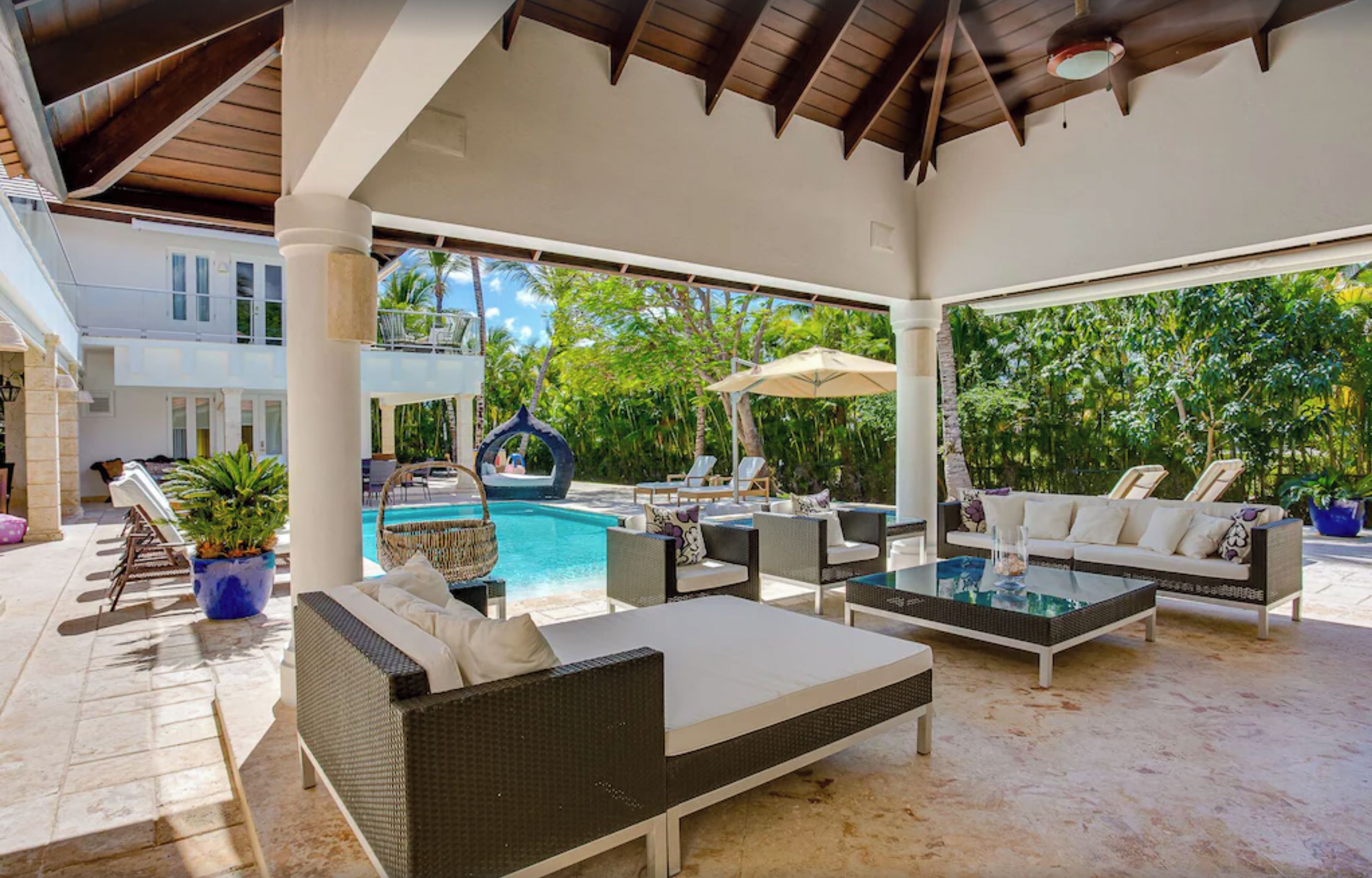 Un espace de vie extérieur abrité, comprenant des chaises longues, une piscine et un jacuzzi.