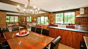 A spacious kitchen with a large island, wooden cabinetry, and a chandelier.