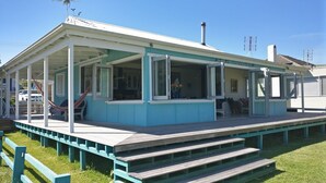 A house with a covered porch, a small deck, and a chimney. - "The Old School House" (Currarong)