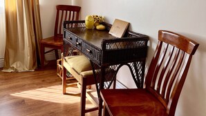 Uma área de refeições com uma mesa, cadeiras e um quadro na parede.