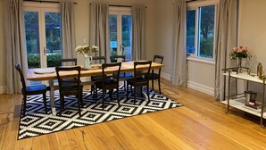 A dining area with a wooden table, black and white patterned rug, and black chairs. - Marden Meadows - Luxury home in Kangaroo Valley (Kangaroo Valley)
