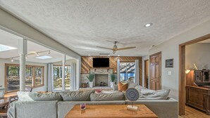 Un salon spacieux avec un canapé d’angle, une table basse en bois et une cheminée.