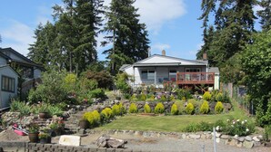 A house with a garden and a dock extending into a body of water.
