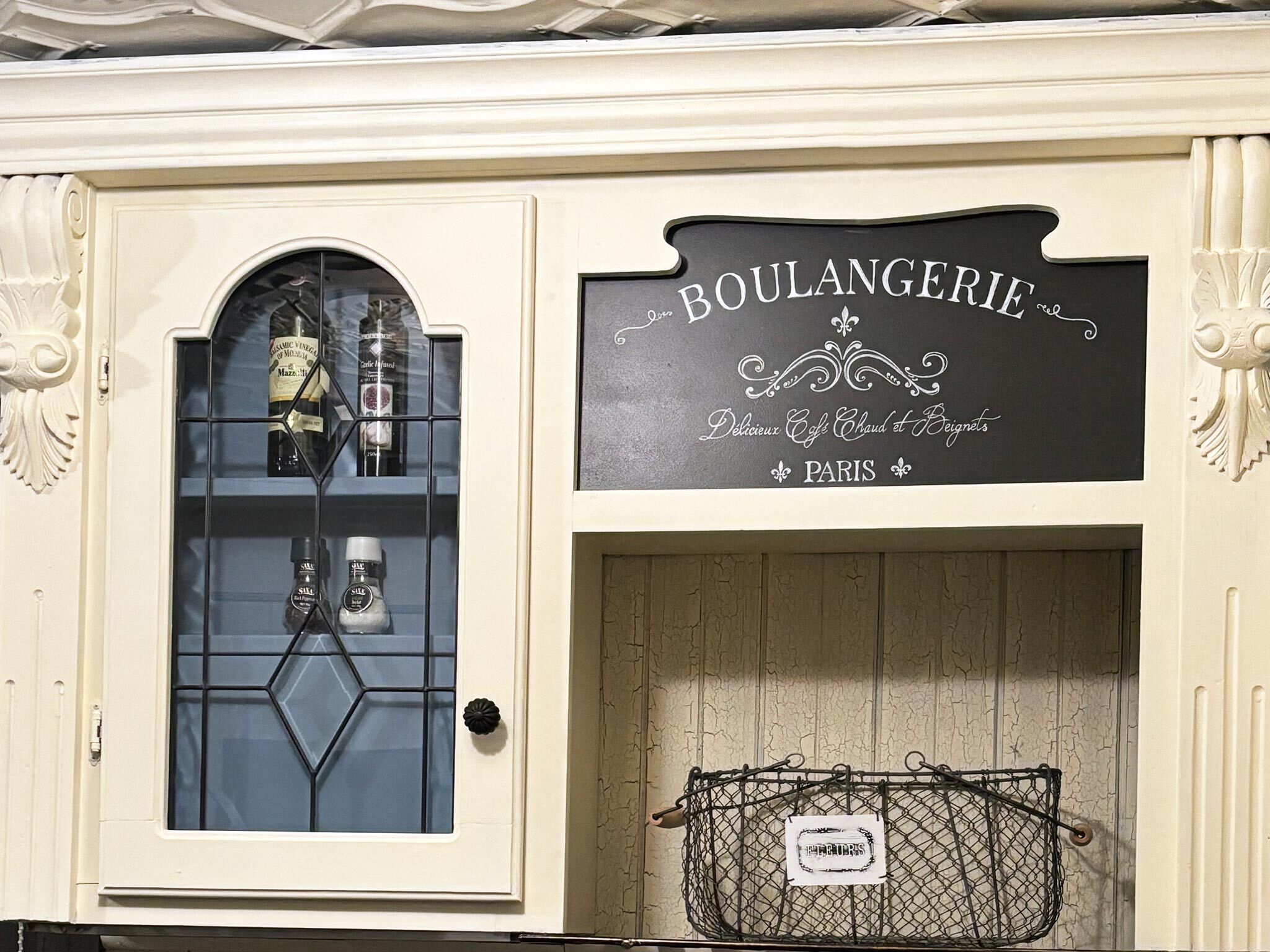 A storefront with a sign reading "BOULANGERIE" and "Delicious Cafe Chaud et Beignets" in Paris.