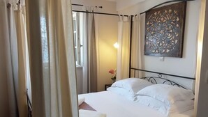 A neatly made bed with white linens and a brown patterned bedspread, a nightstand with a vase of flowers, and a decorative wall piece above the bed. - Villa with  fascinating sea view ,oasis of peace idealf or relaxing ho (Viganj)