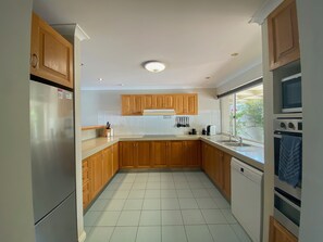 Fully equipped kitchen with stove, double oven, refrigerator and dishwasher