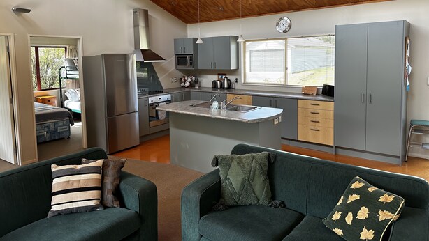 Cocina moderna con una isla central, electrodomésticos integrados y vistas al exterior.