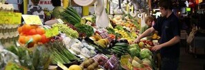 A market stall with various fresh produce and packaged goods.