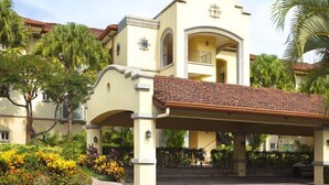 A two-story building with a covered entrance and a tiled roof. - Los Suenos Marina and Resort - Del Mar Luxury Condo 3 Br/2 Ba (Herradurra Beach Jaco)