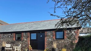 A stone building with a black door, windows, and a gravel driveway. - Cosy rural barn retreat for couples near stunning Cornish coast (Woolley, Bude)