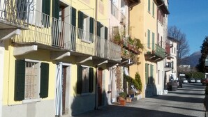 A street with buildings featuring balconies and a cobblestone ground. - Pella: Pella, Lake of Orta: house on the Lake,fantastic view (Pella)