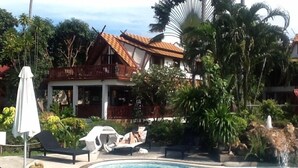 A swimming pool with lounge chairs and a waterfall feature. - Affordable beachside luxury in a beautiful intimate setting. (Ko Samui)