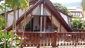 A traditional wooden house with a balcony featuring intricate railings. - Affordable beachside luxury in a beautiful intimate setting. (Ko Samui)