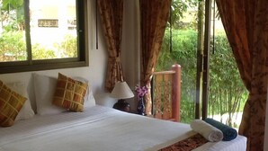 A neatly made bed with white linens, two pillows, and a blue towel. - Affordable beachside luxury in a beautiful intimate setting. (Ko Samui)